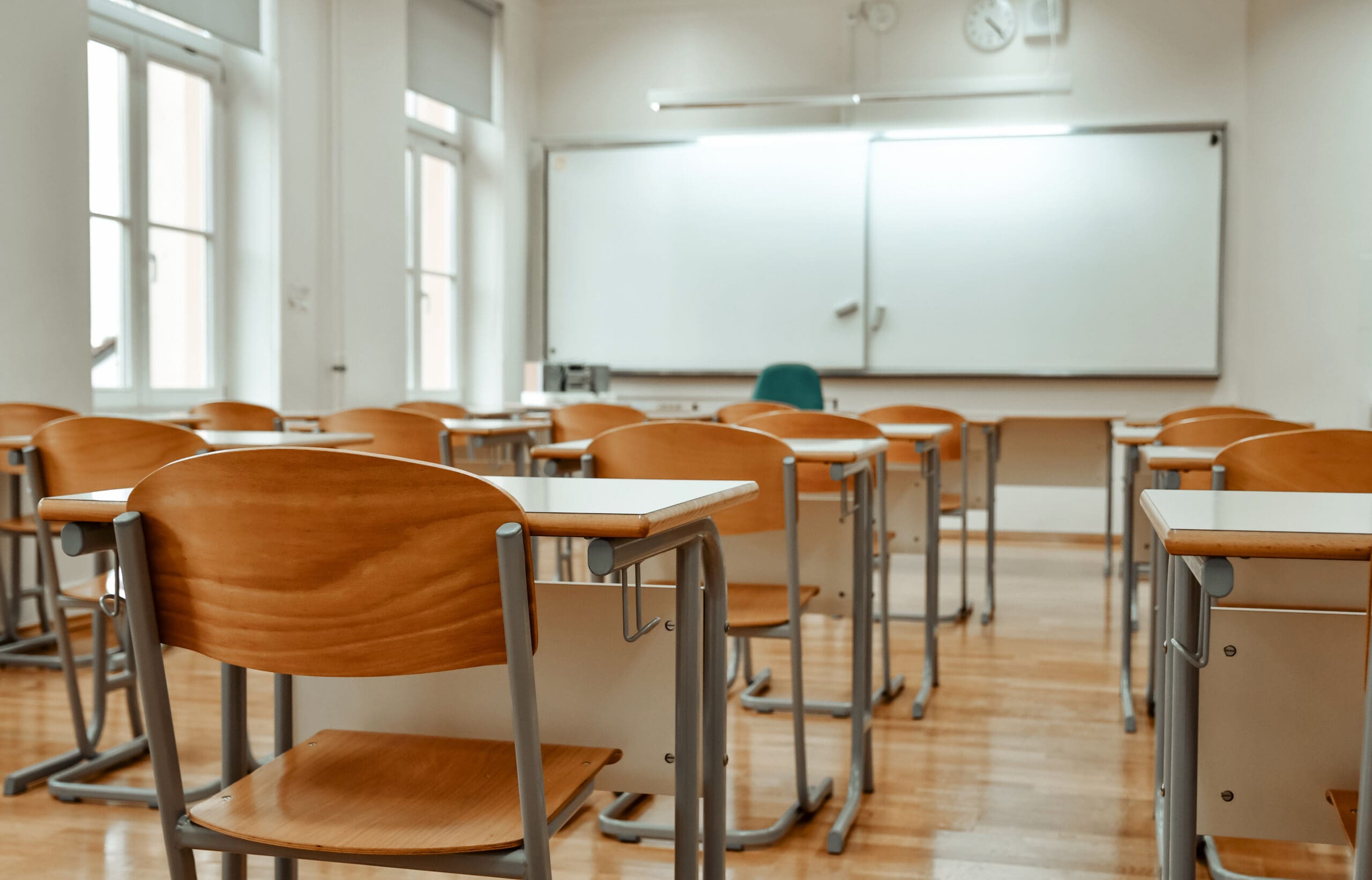 Empty chairs and tables in classroom. No people in school classroom.